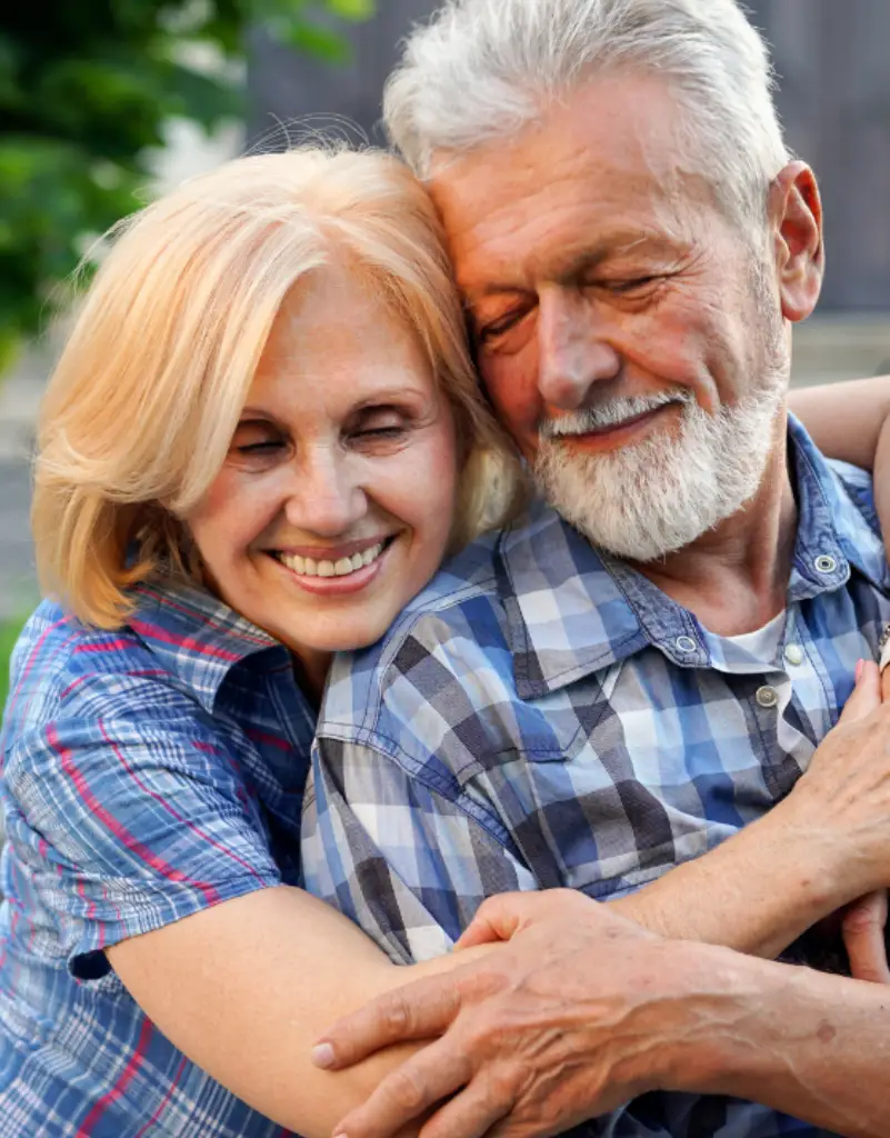 Older couple smiling, leaning toward each other