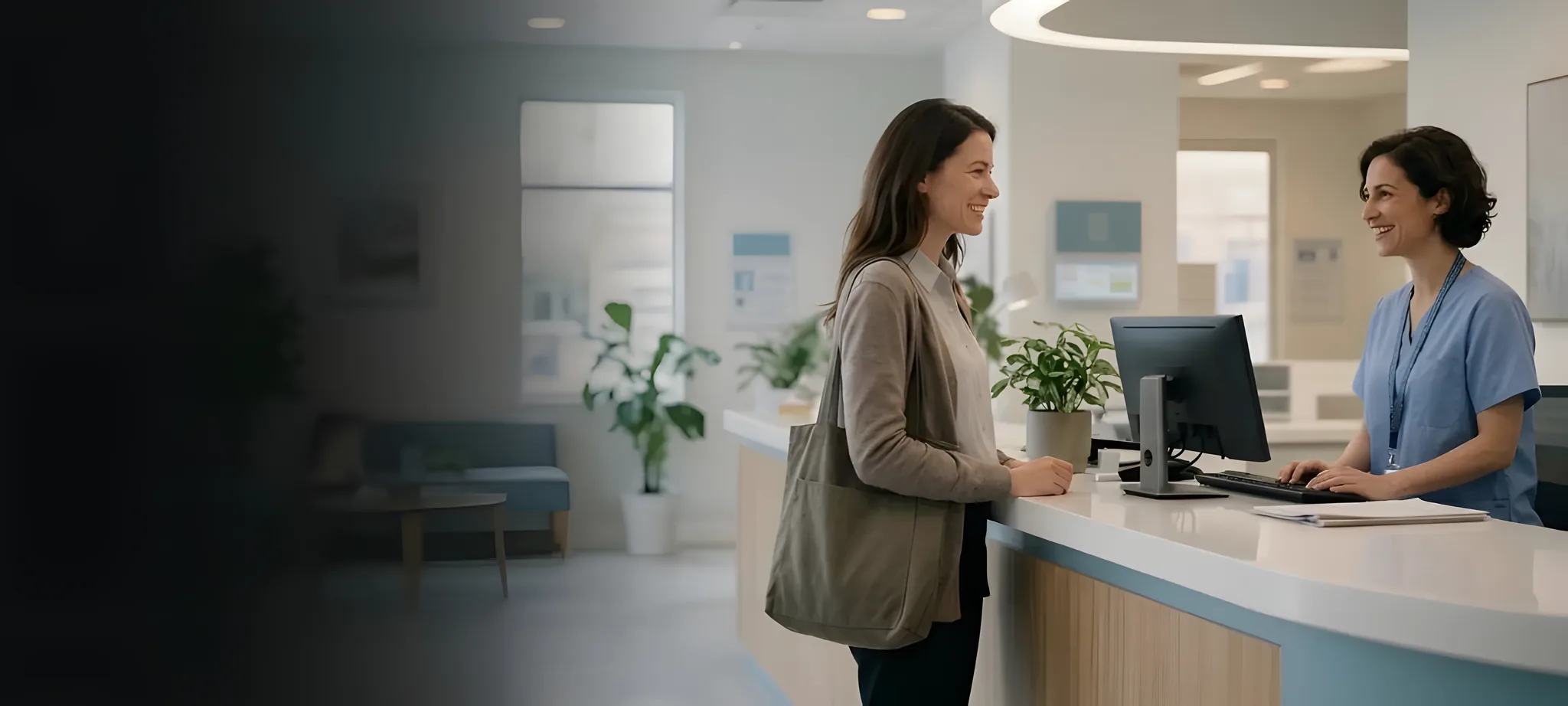 Patient smiling as a dental team member welcomes her at the front desk